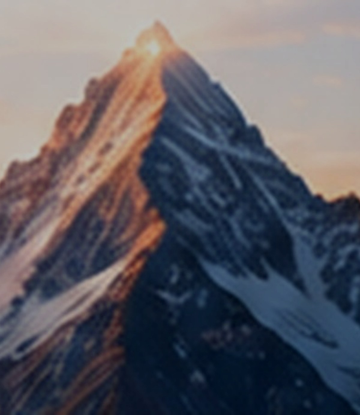 Dark snow-capped mountain peaks under a moody sky.
