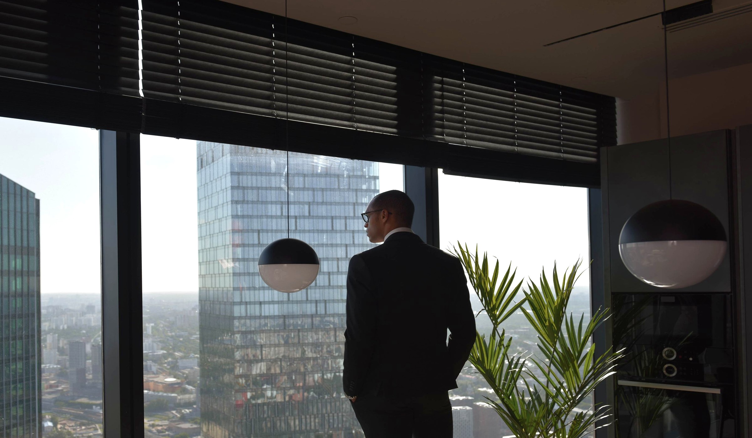 Business leader looking out over a city from a high-rise office.
