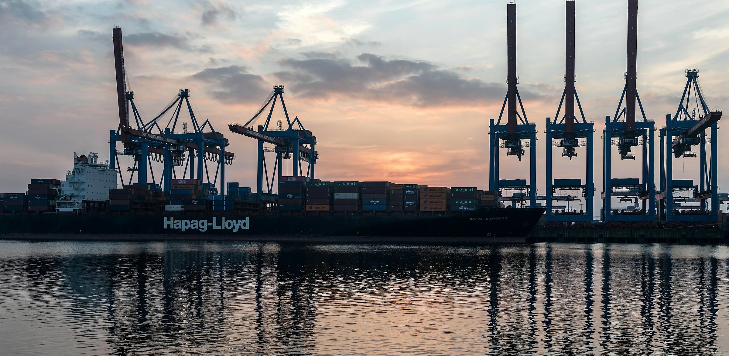 Container ship at a port terminal at dusk.
