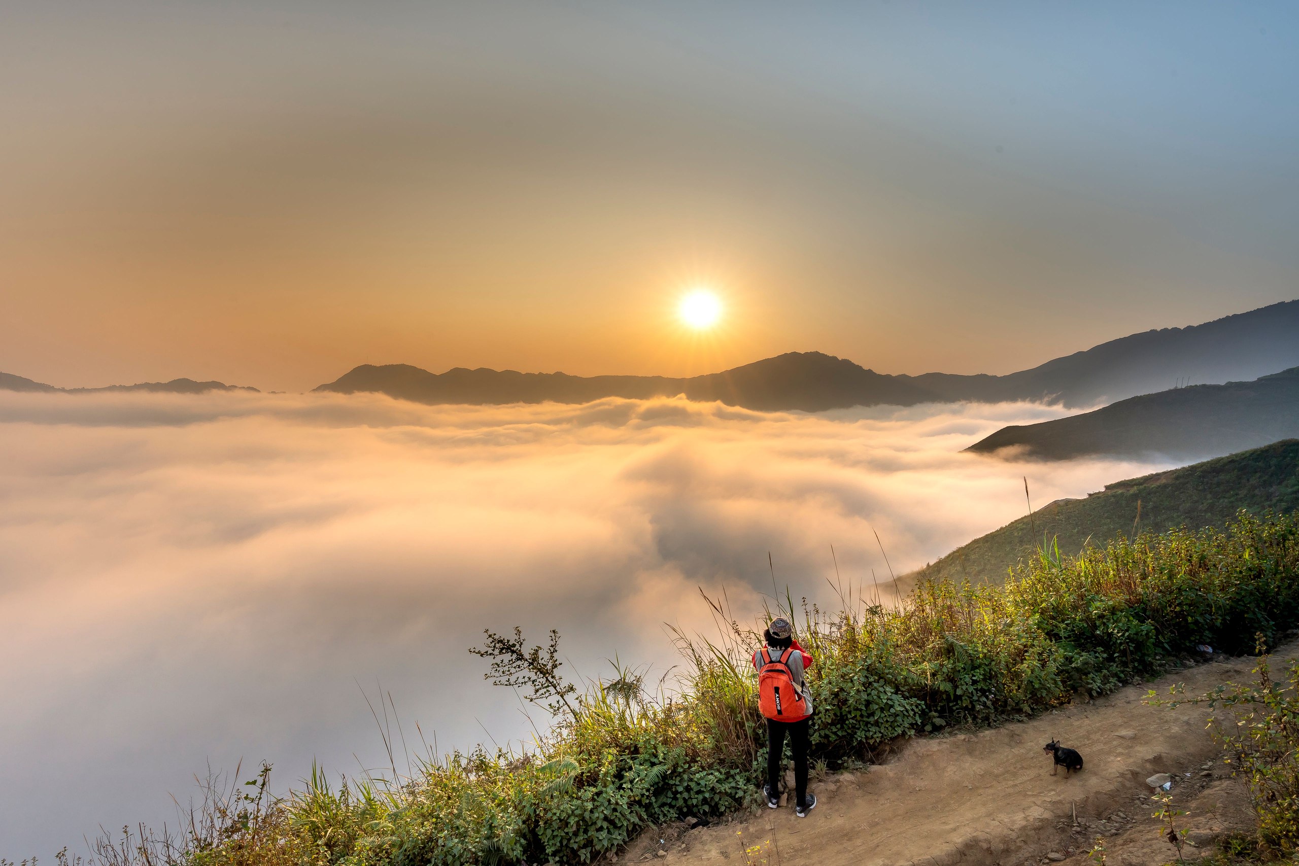 Traveler overlooking mountain ranges at sunrise — transforming possibility into purpose.